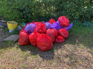 This image shows approximately 14 sacks of rubbish collected on the litter pick .